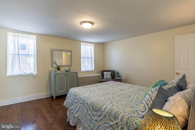 bedroom with baseboards, dark wood-style flooring, and radiator heating unit