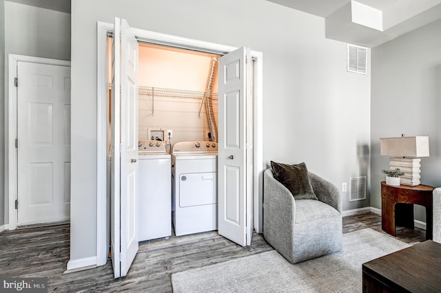 laundry area with visible vents, independent washer and dryer, wood finished floors, and laundry area