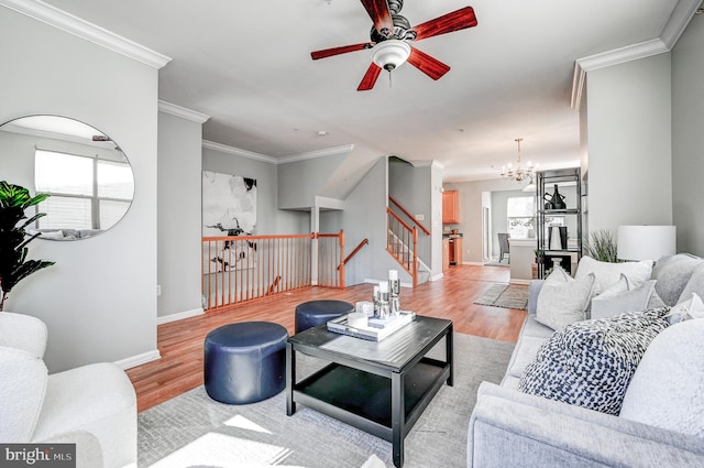 living room featuring stairway, baseboards, wood finished floors, and crown molding