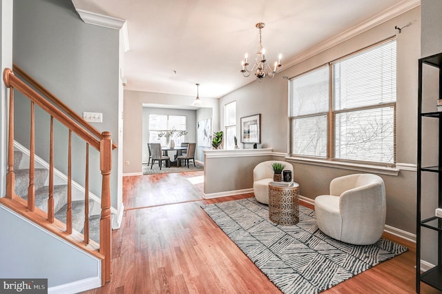 sitting room with an inviting chandelier, stairway, wood finished floors, and baseboards