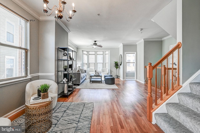 living room featuring stairway, crown molding, baseboards, and wood finished floors