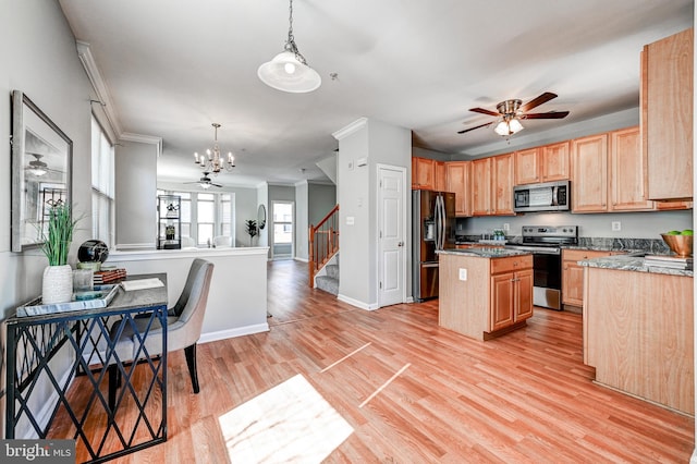 kitchen featuring a kitchen island, appliances with stainless steel finishes, open floor plan, and ceiling fan with notable chandelier