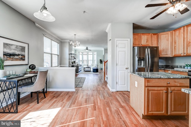 kitchen with decorative light fixtures, dark stone counters, light wood-type flooring, and stainless steel refrigerator with ice dispenser