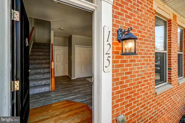 entrance to property featuring brick siding