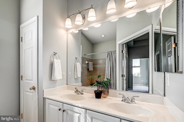 bathroom featuring double vanity, curtained shower, and a sink