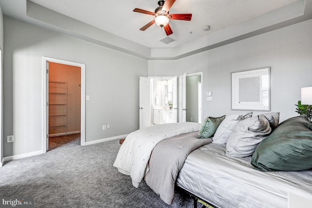 bedroom with a spacious closet, carpet, visible vents, and baseboards