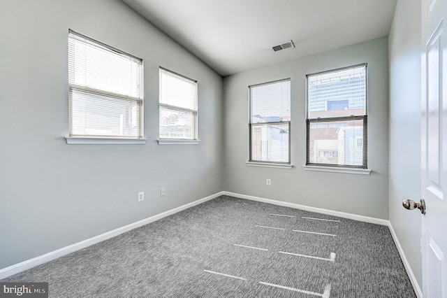 carpeted empty room featuring visible vents and baseboards