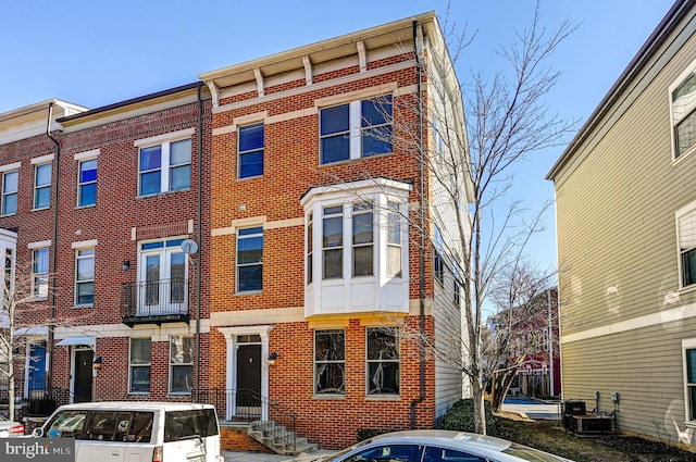 townhome / multi-family property with brick siding and central AC