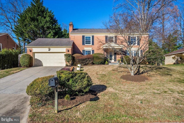 view of front of house featuring driveway, a chimney, an attached garage, and a front yard