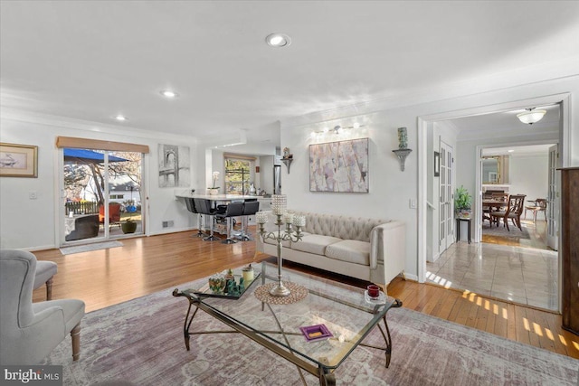 living area featuring recessed lighting, ornamental molding, baseboards, and wood finished floors