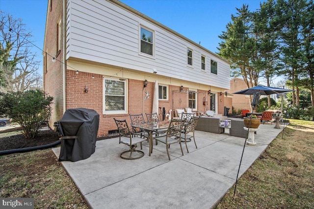 rear view of house with an outdoor living space, a patio, brick siding, and outdoor dining space