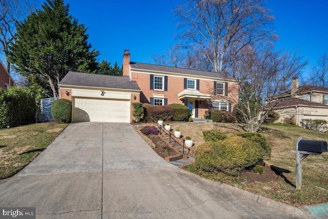 view of front facade with a front lawn, concrete driveway, a garage, brick siding, and a chimney