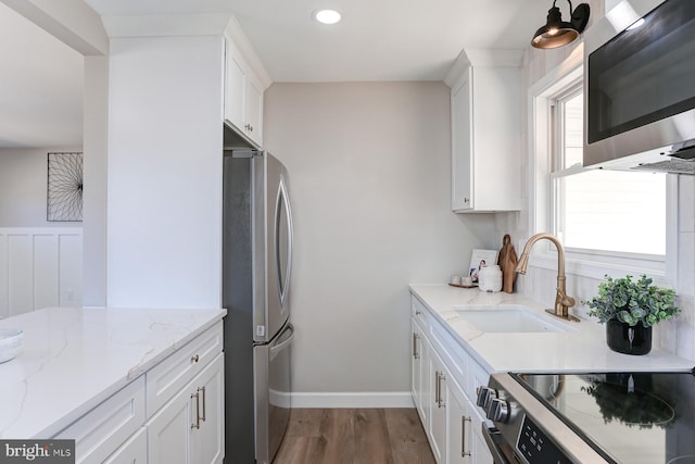 kitchen featuring white cabinetry, stainless steel appliances, and a sink