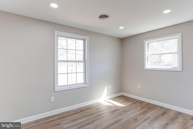 unfurnished room with visible vents, plenty of natural light, and baseboards