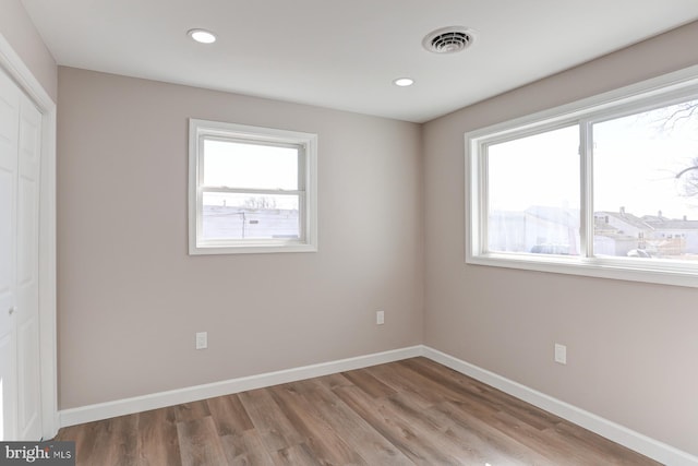 unfurnished bedroom with visible vents, wood finished floors, recessed lighting, a closet, and baseboards