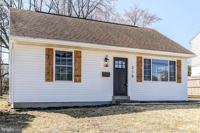 bungalow with fence, roof with shingles, and entry steps