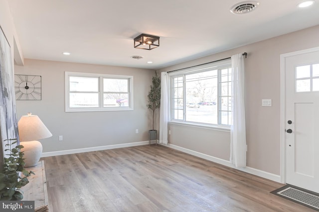 entrance foyer featuring visible vents, baseboards, and wood finished floors