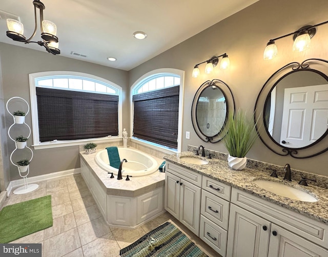 full bathroom with double vanity, tile patterned flooring, a bath, and a sink