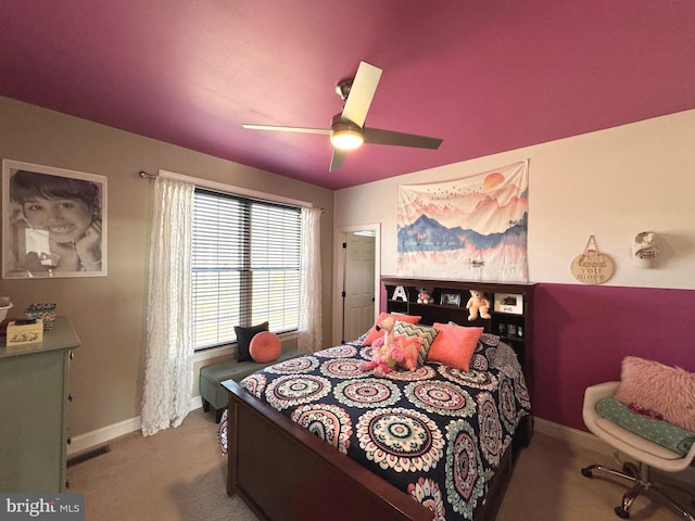 carpeted bedroom with visible vents, baseboards, and a ceiling fan