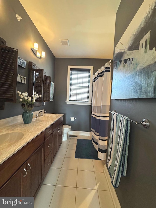 bathroom featuring visible vents, toilet, a sink, tile patterned flooring, and double vanity