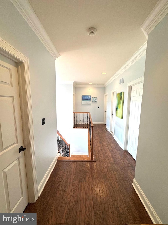 corridor featuring visible vents, an upstairs landing, wood finished floors, crown molding, and baseboards