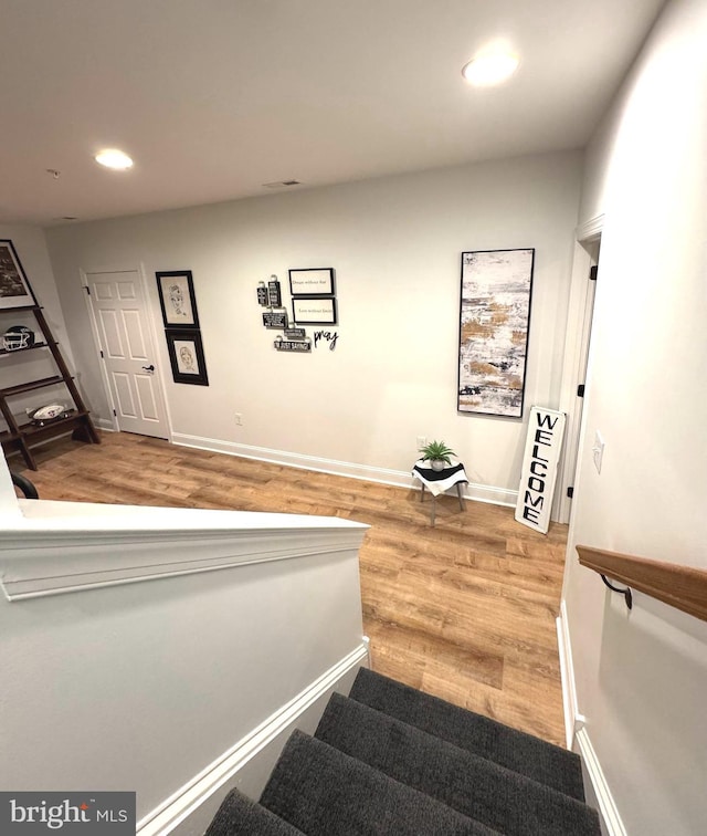 staircase featuring visible vents, recessed lighting, baseboards, and wood finished floors