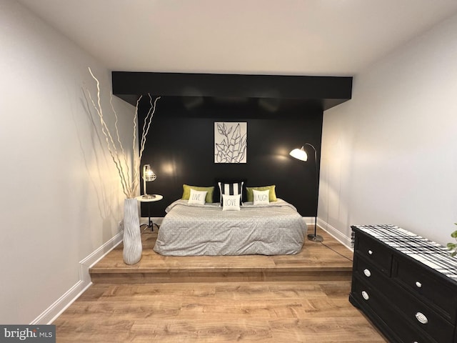 bedroom with light wood-type flooring and baseboards