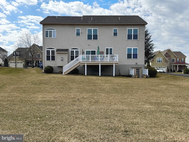 back of house with a wooden deck, a lawn, and stairs