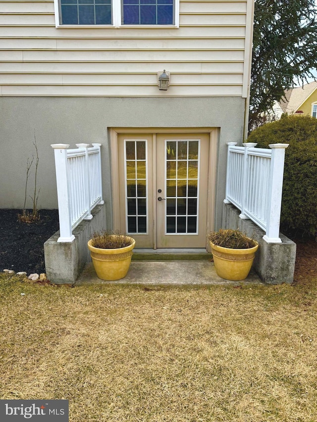 property entrance with stucco siding and french doors