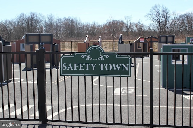 community / neighborhood sign featuring fence