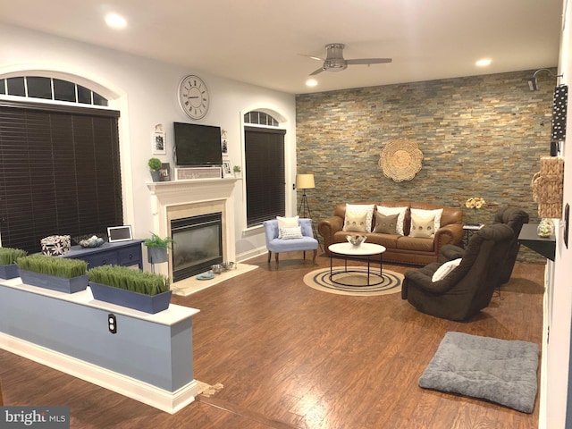 living room with recessed lighting, wood finished floors, a glass covered fireplace, and a ceiling fan