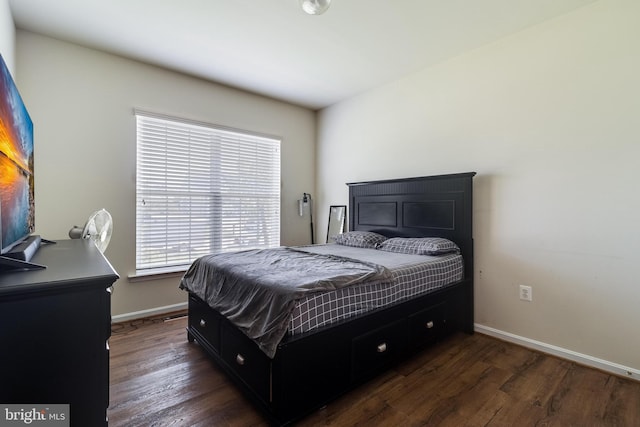 bedroom with baseboards and dark wood-style flooring