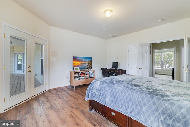 bedroom with visible vents, french doors, and wood finished floors