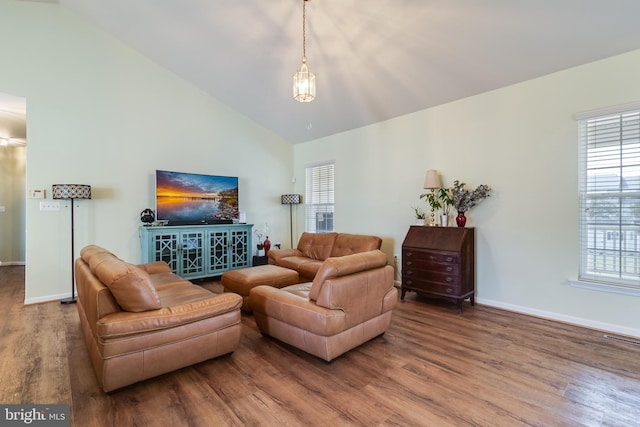 living area featuring visible vents, baseboards, high vaulted ceiling, and wood finished floors