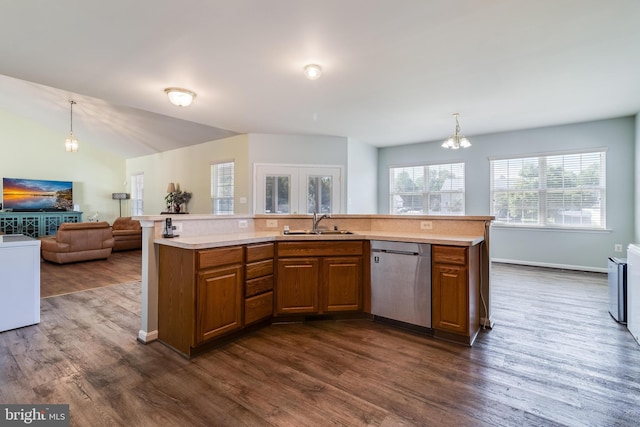 kitchen featuring stainless steel dishwasher, light countertops, brown cabinetry, and a sink