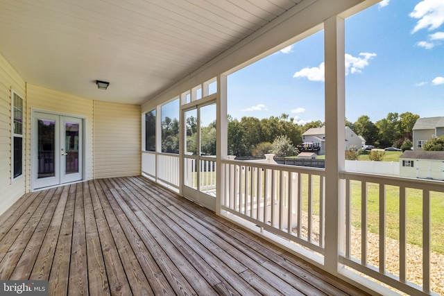 wooden terrace featuring fence, a shed, an outdoor structure, french doors, and a lawn