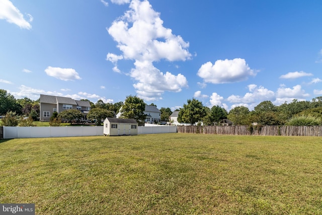 view of yard with a fenced backyard, an outdoor structure, and a shed