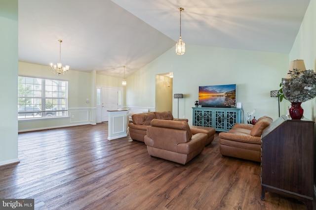 living room featuring dark wood-type flooring, wainscoting, a chandelier, and vaulted ceiling