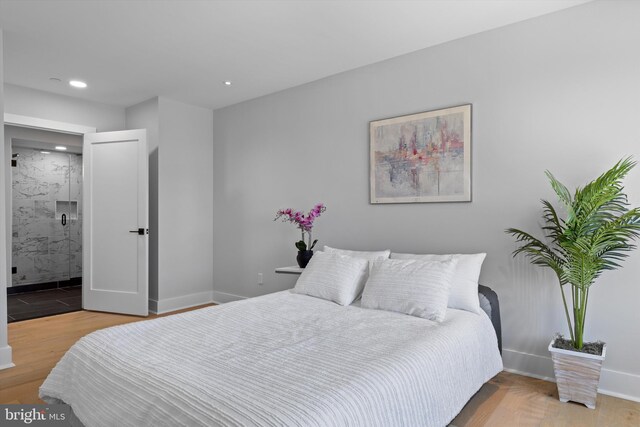 bedroom with recessed lighting, ensuite bath, baseboards, and wood finished floors