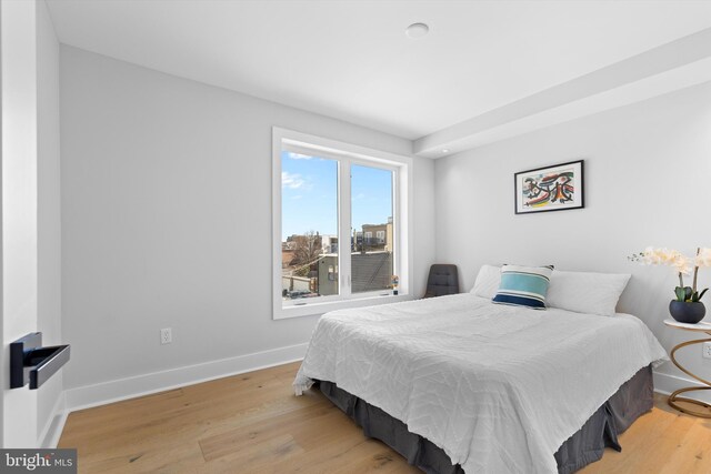 bedroom with baseboards and wood finished floors