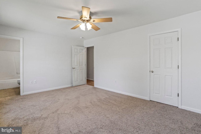 unfurnished bedroom with baseboards, carpet, and ensuite bath