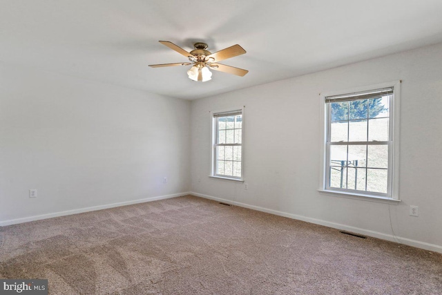 unfurnished room featuring visible vents, carpet floors, baseboards, and a ceiling fan