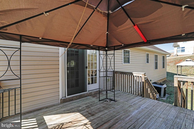 wooden terrace featuring a gazebo and cooling unit