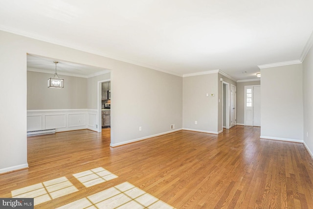 unfurnished room featuring a chandelier, crown molding, a baseboard heating unit, and light wood-style floors