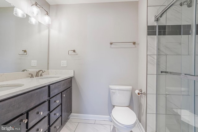 bathroom featuring toilet, a stall shower, a sink, double vanity, and baseboards