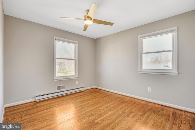 empty room featuring ceiling fan, wood finished floors, baseboards, and a baseboard radiator