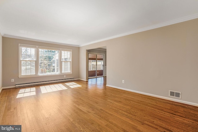 spare room with crown molding, wood finished floors, visible vents, and a baseboard radiator