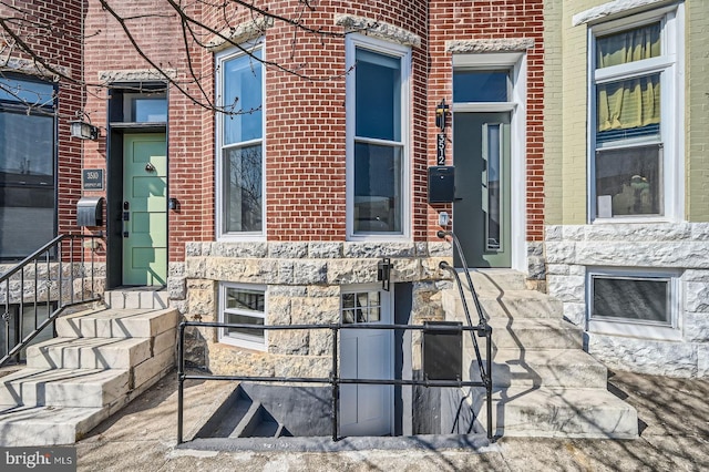 doorway to property with brick siding and stone siding