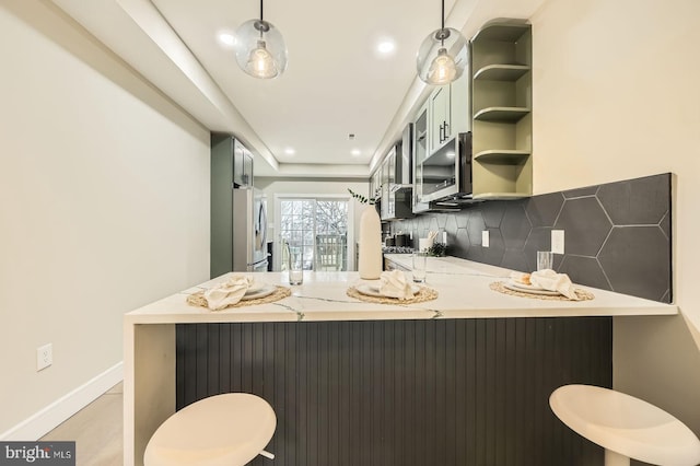 kitchen with a breakfast bar, decorative backsplash, appliances with stainless steel finishes, a peninsula, and open shelves