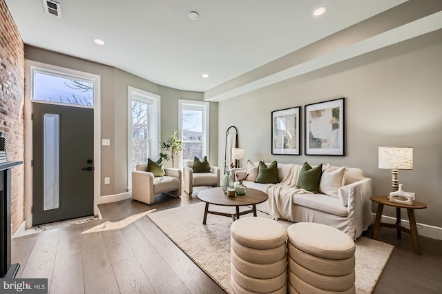 living room featuring recessed lighting, visible vents, wood-type flooring, and baseboards